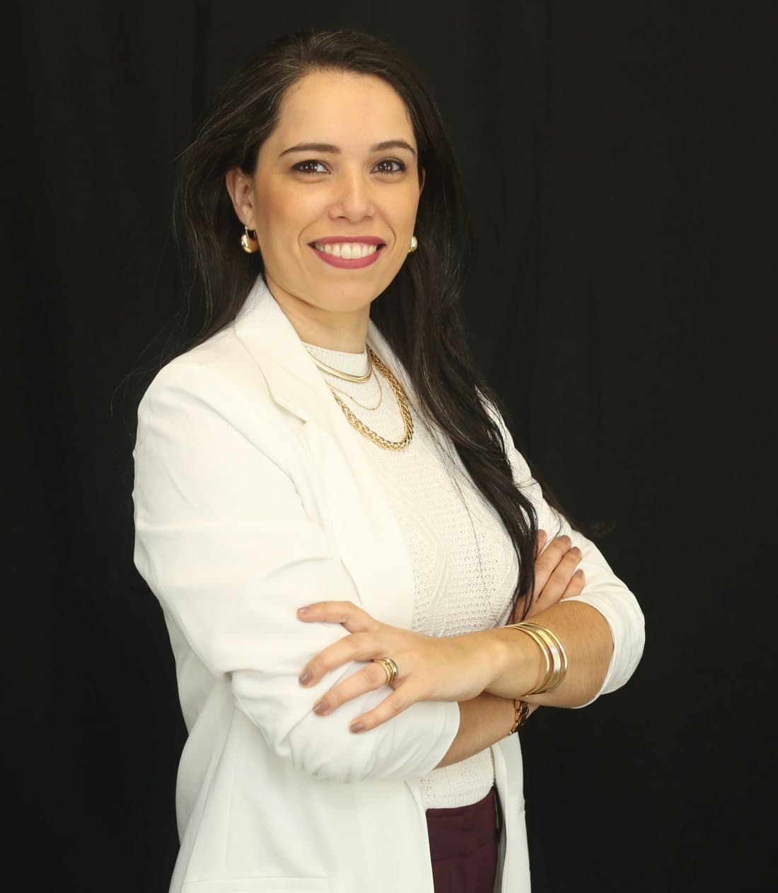 Carol Mendes, contadora, sorrindo de braços cruzados
